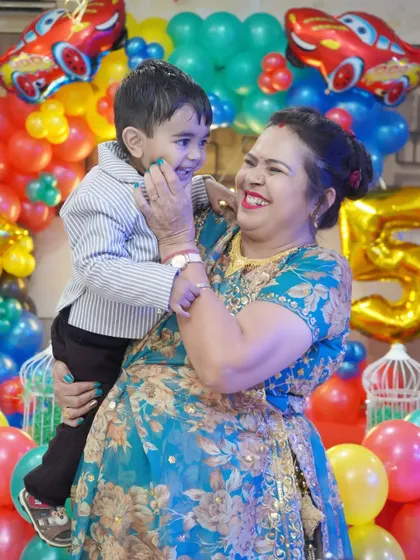 A joyful, candid photo of a grandmother and her grandson sharing a laugh during his fifth birthday party.