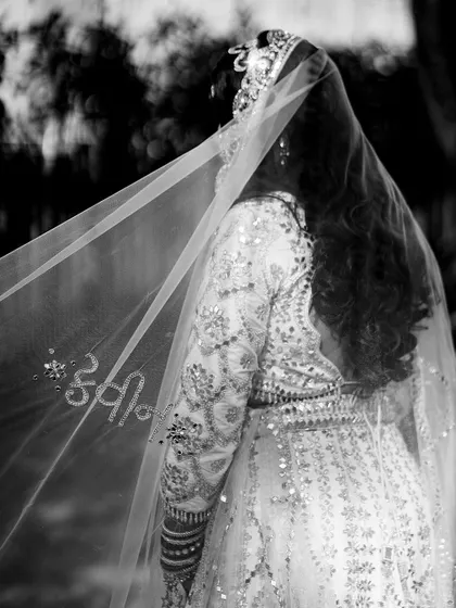 Personalization is at the heart of what we do. For this bride, we added a deeply romantic touch by hand-embroidering her husband's name onto her wedding veil. It’s these small, meaningful details that transform an outfit into a cherished memory.