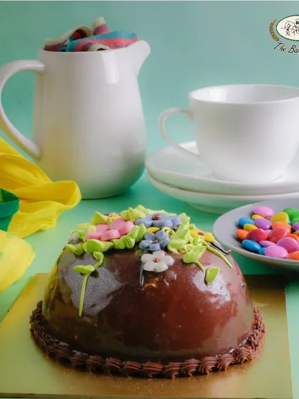 Shaped like a large Easter egg, this chocolate cake is covered in a glossy ganache and decorated with spring flowers. It's an elegant and delicious centerpiece.