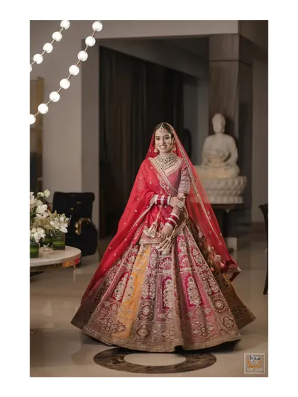 A full-length portrait of the bride in her magnificent multi-colored lehenga.