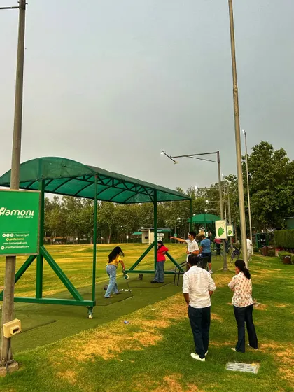 A group of friends watches as one of them takes a swing, highlighting the social aspect of a trip to the range.