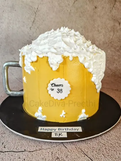 Cheers to 38! This impressive 12-inch tall beer mug cake weighs 4 kg and is designed to look like a frosty, overflowing mug of beer. The foam is created with piped buttercream for a realistic effect.