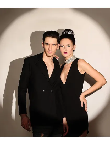 A powerful and stylish couple's shot with a spotlight effect. The pose is strong and connected, perfect for a fashion brand or editorial.