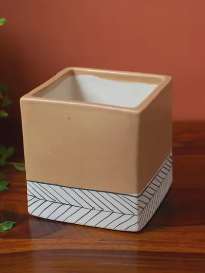 An empty view of the Marley planter, highlighting its clean lines and the contrast between the earthy terracotta color and the hand-painted white pattern.