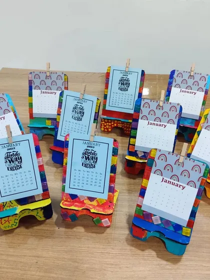 A collection of the completed DIY desk calendars, each with a unique, colorful base painted by a child at the party.