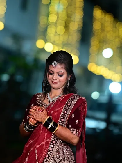 A candid moment from the reception. The bride's makeup is designed to look beautiful even in the warm glow of evening lights, highlighting her features perfectly.