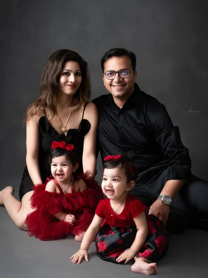 A happy family portrait with twin girls, capturing a moment of shared laughter.
