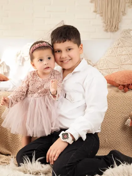 A protective big brother with his baby sister. Capturing these sibling relationships is one of our favorite things.