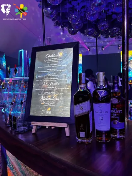 A premium bar display featuring top-shelf whiskies like The Macallan and The Glenlivet. The custom menu and moody lighting create a sophisticated atmosphere for any event.