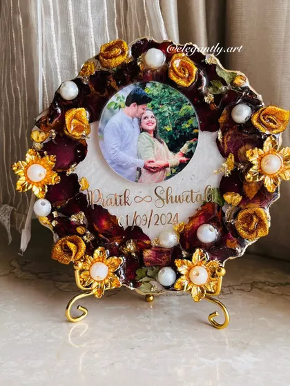 A cute, budget-friendly photo frame made using an engagement garland. The preserved flowers and golden accents create a lovely and affordable keepsake.
