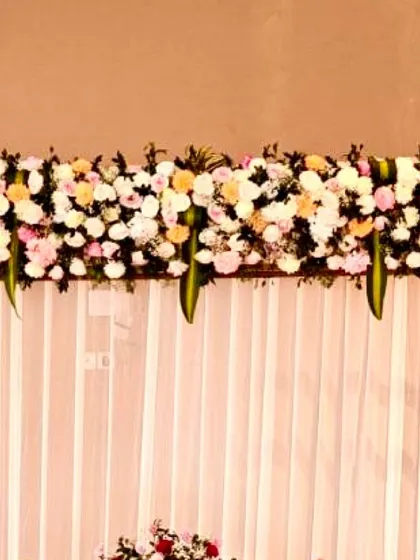 A close-up of the lush floral runner made with fresh roses and chrysanthemums, which topped the backdrop for a naming ceremony.