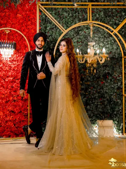 Another angle of the couple against the stunning floral backdrop, showing their impeccable style.