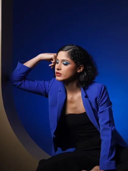 A contemplative, moody portrait. The blue light creates a calm, introspective atmosphere, while the pose remains elegant.