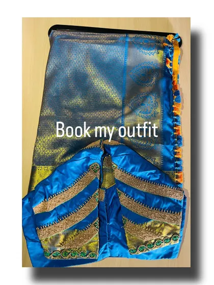 Here is another custom blouse design for a silk saree. The focus is on the sleeve work, with multiple bands of gold zari and green threadwork creating a stacked, bracelet-like effect that elevates the entire look.