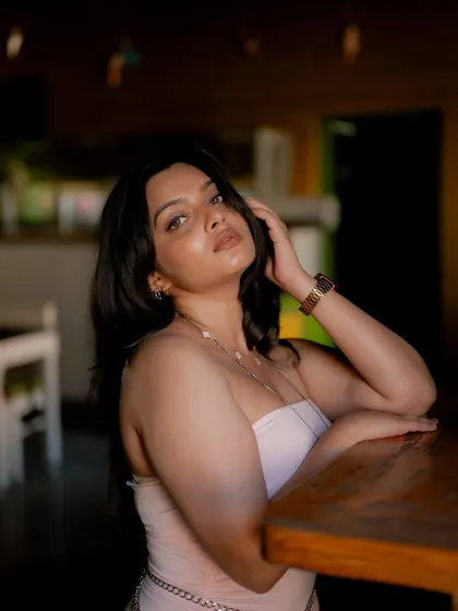 A portrait of a model in a cafe, looking over her shoulder. The soft lighting and her expression create an intimate and stylish shot.