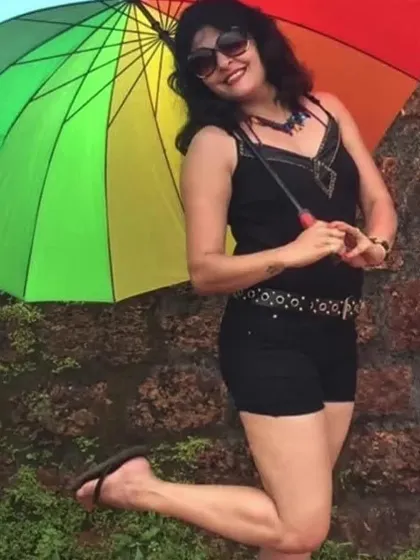 A fun holiday look with black shorts and a black tank top, accessorized with a colorful umbrella. Casual style should be practical but never boring.