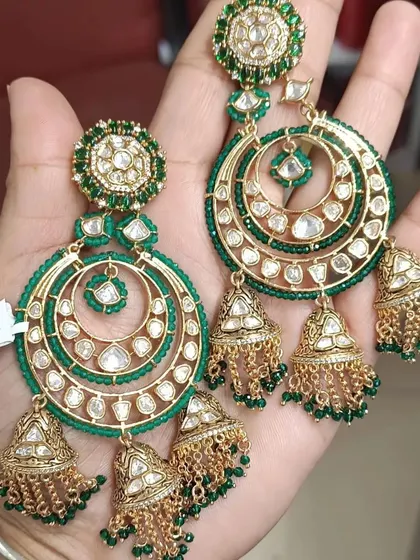 A full view of the popular green circular chandbalis with multiple jhumka drops. The fine kundan work and green beading make these earrings a stunning choice for any festive occasion.