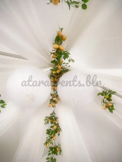 A view from above of the draped ceiling at the Sicilian-themed party. The white fabric and hanging lemon branches create a beautiful and unique canopy for the event.