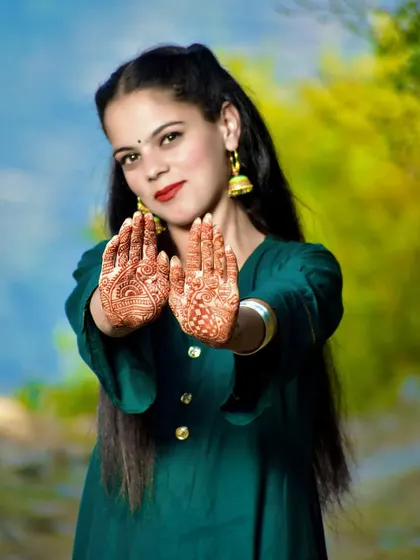 A classic pose for showing off the detailed henna art on both hands, an important part of the pre-wedding preparations.