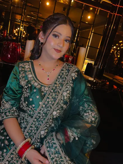 A classic portrait in a beautifully lit setting. The makeup is soft and flattering, with a focus on clean skin and defined features, making it a perfect look for any evening event.