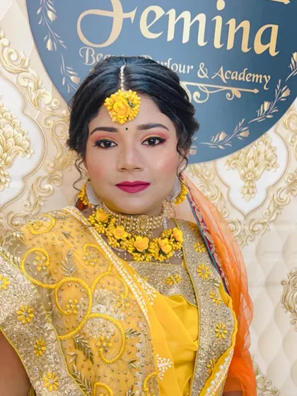 A front-facing portrait of the Haldi bride, showing how the floral jewellery and bright makeup come together.
