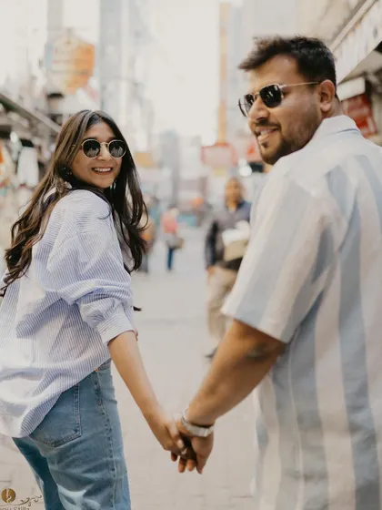 A playful "follow me to" style shot as the couple explores a bustling market. This captures the fun and adventurous spirit of a pre-wedding shoot in the heart of the city.