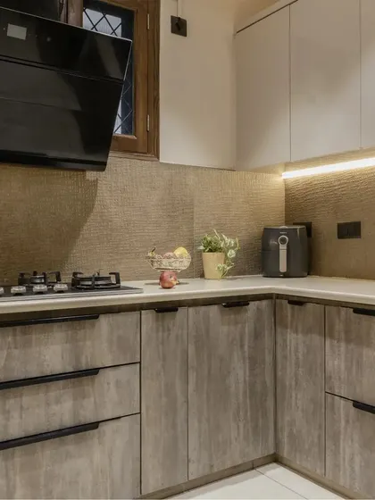 Another angle of the Gurgaon kitchen, showcasing the combination of wood-finish lower cabinets and light-colored upper cabinets for a balanced look.