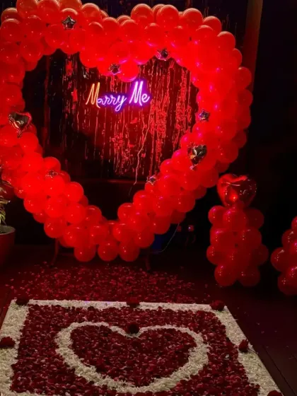 For a bold and passionate statement, I created this large heart-shaped arch using red balloons. Paired with a "Marry Me" neon sign and a rose petal carpet, it's a classic romantic proposal idea.