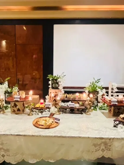 We create an elegant and festive atmosphere for Diwali card parties. This beautiful table setup features a variety of our appetizers and desserts, illuminated by the warm glow of candles.