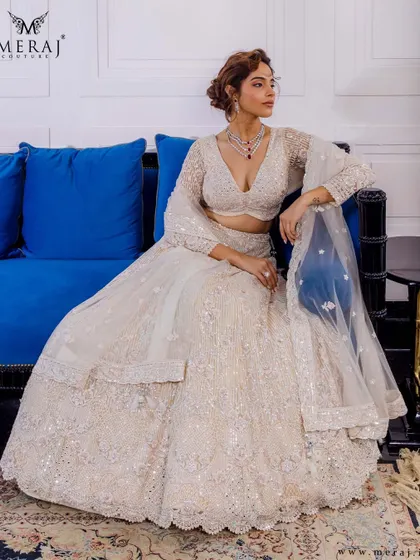 This ivory lehenga from the 'Ruvaah' collection is a masterpiece of design, with its delicate sequin embellishments and timeless silhouette.