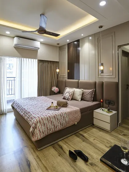 A master suite designed to feel like a five-star hotel room. The tall, upholstered headboard adds a sense of grandeur, while the mix of wood-look flooring and soft textiles creates a warm and inviting atmosphere.