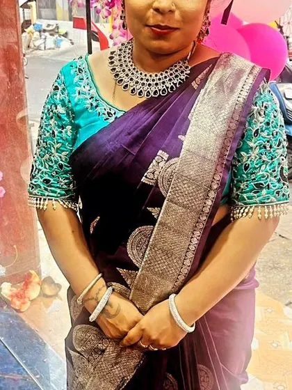A close-up of the beautifully embroidered blouse and the rich purple saree.