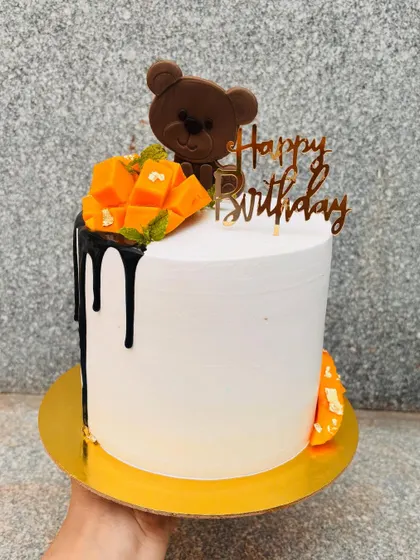The season's first mango cake. This design features a dark chocolate drip, fresh mango chunks, and a cute chocolate teddy bear.