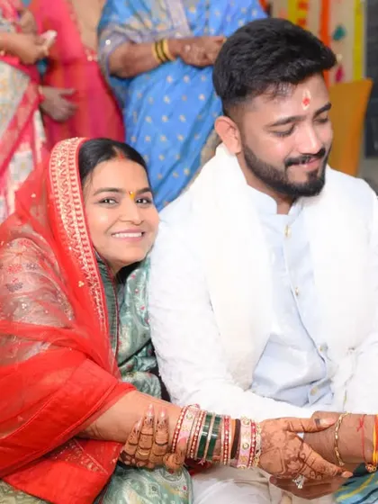 A sweet, smiling interaction between the couple as they participate in the puja rituals.