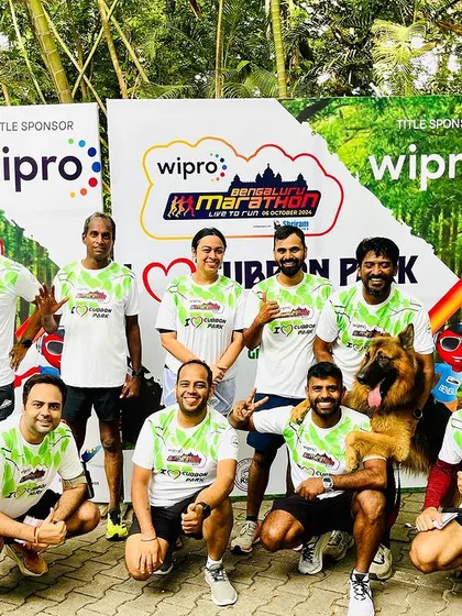 The RTC team, along with a furry supervisor, posing at the Wipro Bengaluru Marathon green initiative event in Cubbon Park.