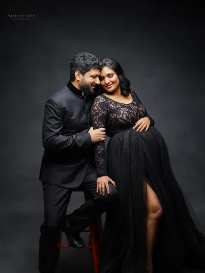 An intimate seated portrait of the couple. The black gown and suit create a formal, elegant look, while the pose feels warm and connected.