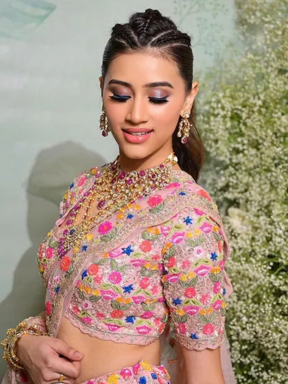 A colorful and fresh Mehendi look with a braided ponytail and vibrant pink and purple eyeshadow.