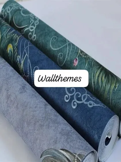 A collection of wallpaper rolls with different peacock feather designs and textures.