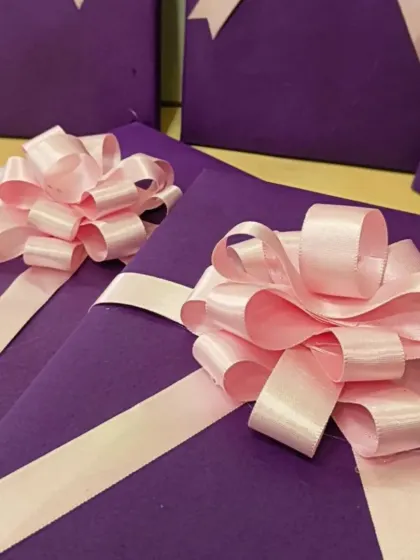 Another view of the gifts for the Adani Foundation's Women's Day event. The simple, elegant wrapping with a fluffy pink bow was chosen to honor the attendees.