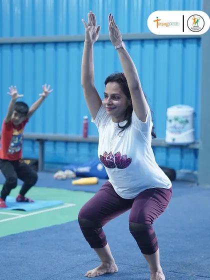 We believe in holistic training, which includes practices like yoga for flexibility and focus. Here, our yoga instructor guides a student during our International Yoga Day celebrations.