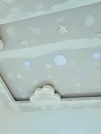 A complete sky-themed ceiling in progress, with clouds, stars, and a moon. This unpainted gypsum design shows the full scope of a creative project for a child's room.