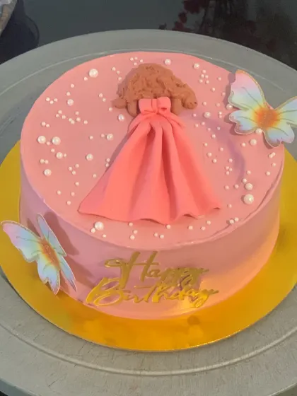 A pretty pink cake with a doll's dress and butterflies. This is a simple and sweet design for a little one's birthday.
