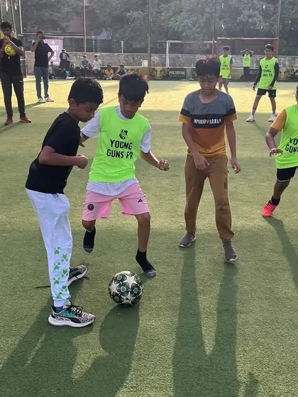 Three young players battling for the ball, showing the friendly competition we encourage at our football events.