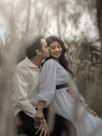 A sweet kiss shared in a field of tall, wild grass. I often shoot through natural elements like grass to create a dreamy, intimate, and voyeuristic feel.