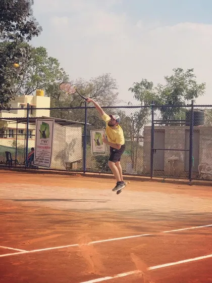 A player is captured at the peak of his jump serve during the Tennis360 Men's Open Tour.