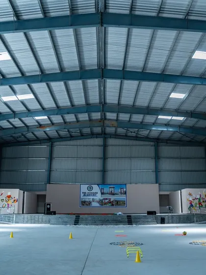 The versatile play zone and assembly hall at Konark Academy. Housed under a massive Pre-Engineered Building (PEB) structure, this space is equipped with a stage and can be used for sports, performances, and large school gatherings.