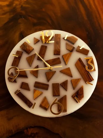 This photo, taken by the client, shows the wood and resin clock in its new home. The abstract arrangement of teak wood pieces against the white resin complements the wooden furniture perfectly.