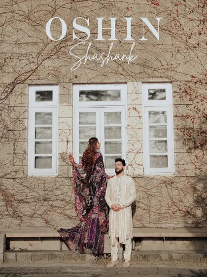 A stylish portrait of the couple against the ivy-covered wall of Woodville Palace. Their traditional outfits contrast beautifully with the heritage architecture.