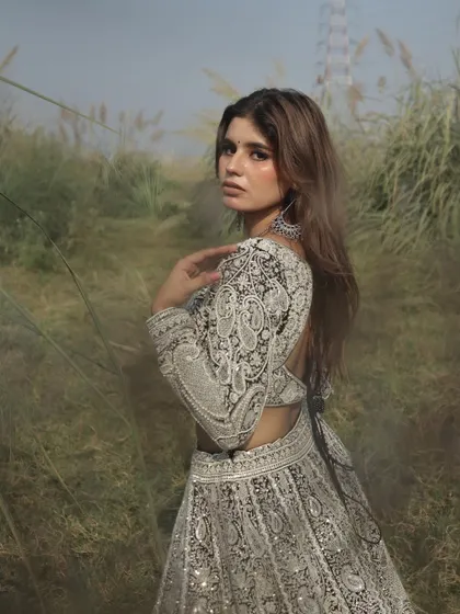 A close-up portrait showcasing the detailed embroidery on the sleeves and the modern, edgy vibe of this unique lehenga.
