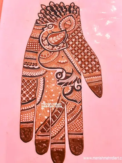 A finished, full-hand design featuring a prominent peacock motif. The combination of the bold peacock with delicate filler patterns creates a balanced and stunning bridal look.